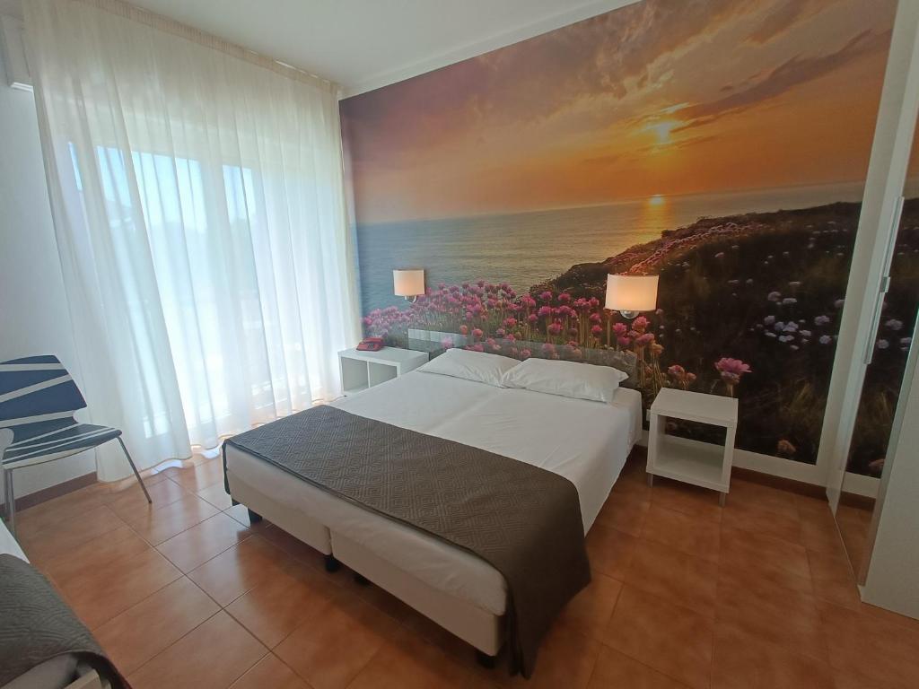 sypialnia z łóżkiem i obrazem na ścianie w obiekcie Hotel Merano w Grado