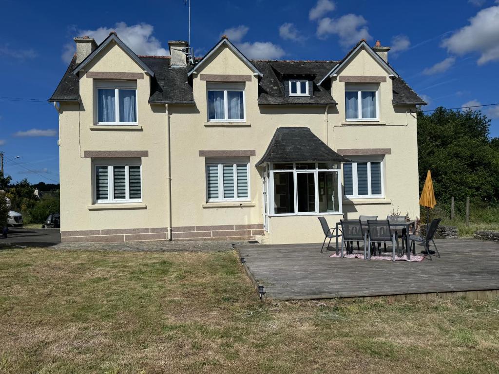 une maison avec une table et des chaises devant dans l'établissement Gîte de Kerg’O, à Cléden-Poher