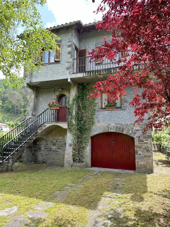 a building with a red door and a red garage at La Torre de la Vall de Camprodon in Llanars