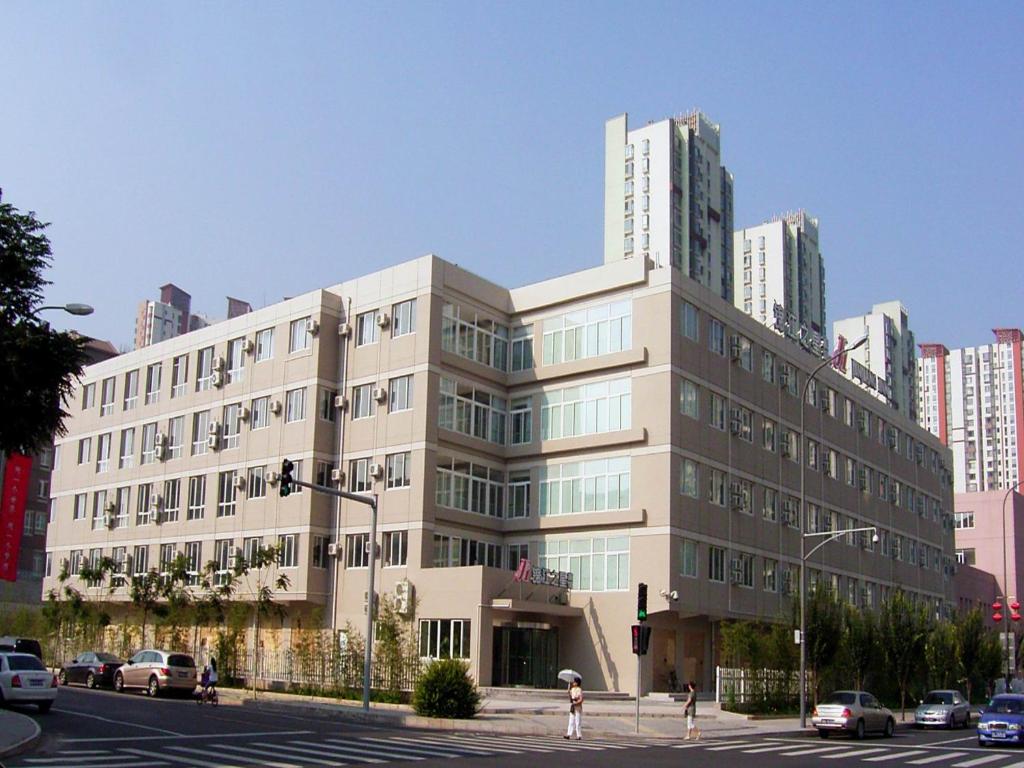 a large building on the corner of a city street at Jinjiang Inn Beijing Olympics Park in Beijing