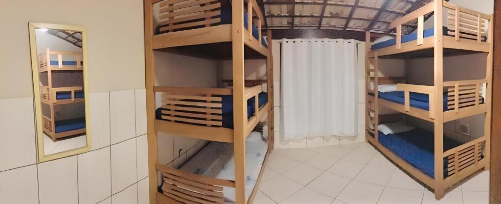 Pokój z drewnianymi półkami w pokoju w obiekcie Nossa Casa w mieście Arraial do Cabo