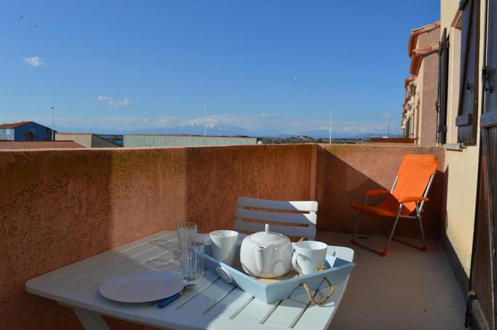 une table et des chaises sur un balcon avec une table et des chaises dans l'établissement Appart 3 pièces mezz 6 couchages PORT LEUCATE NATURISME PL010-1406, à Port-Leucate