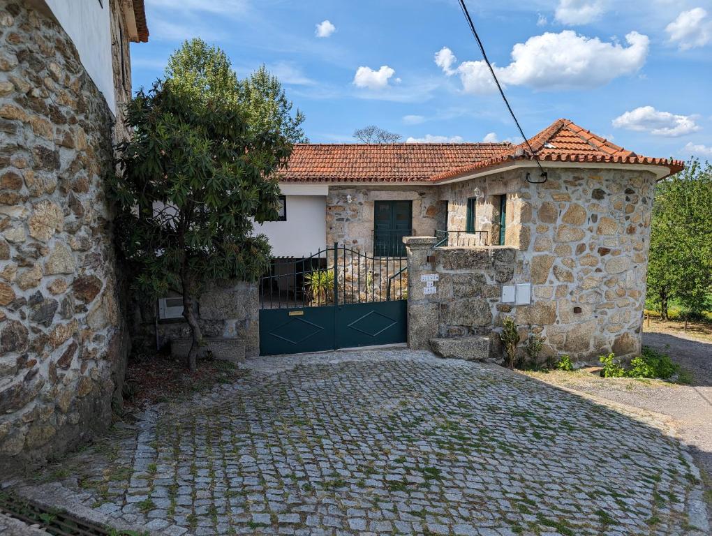 a stone house with a gate and a driveway at Quinta da Lage Agroturismo e Enoturismo in Celorico de Basto