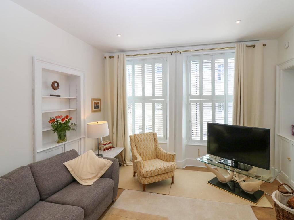 Una sala de estar con un sofá y un televisor. en 1A Carmelite Street, en Banff