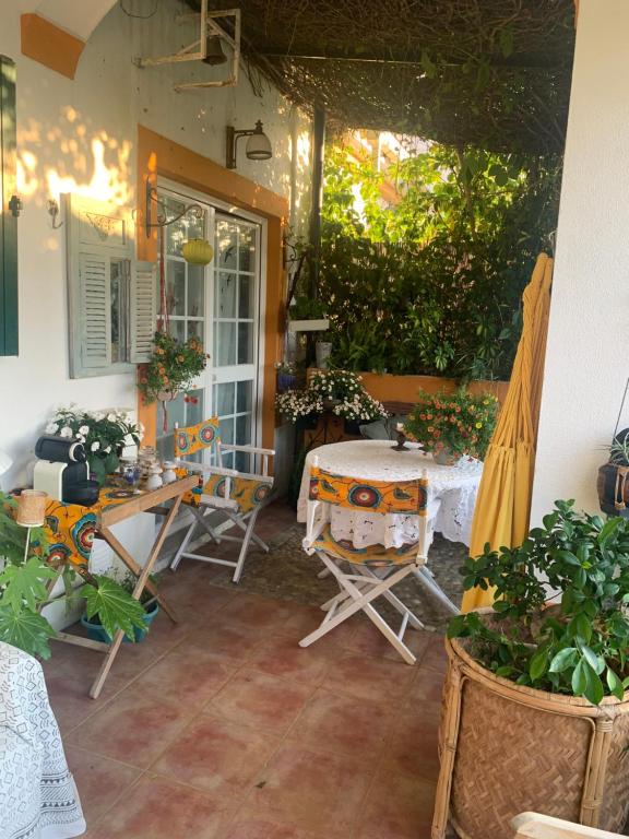 a patio with a table and chairs and plants at A Casa do Lagar in Azeitao