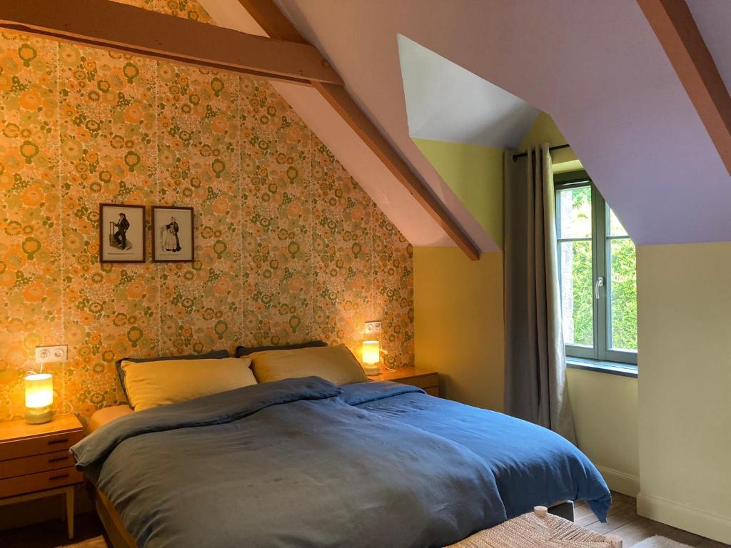 una camera da letto con un letto blu e una finestra di Encore une fois, La maison coloréé a Locmalo