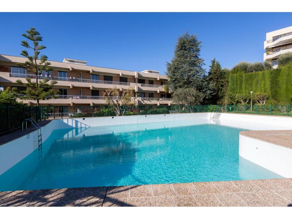 une grande piscine devant un immeuble dans l'établissement Ciel de Fabron, à Nice