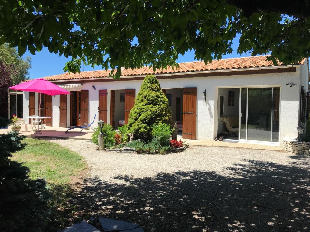 una casa con un árbol delante en Villa de vacances bord de mer, en Meschers-sur-Gironde