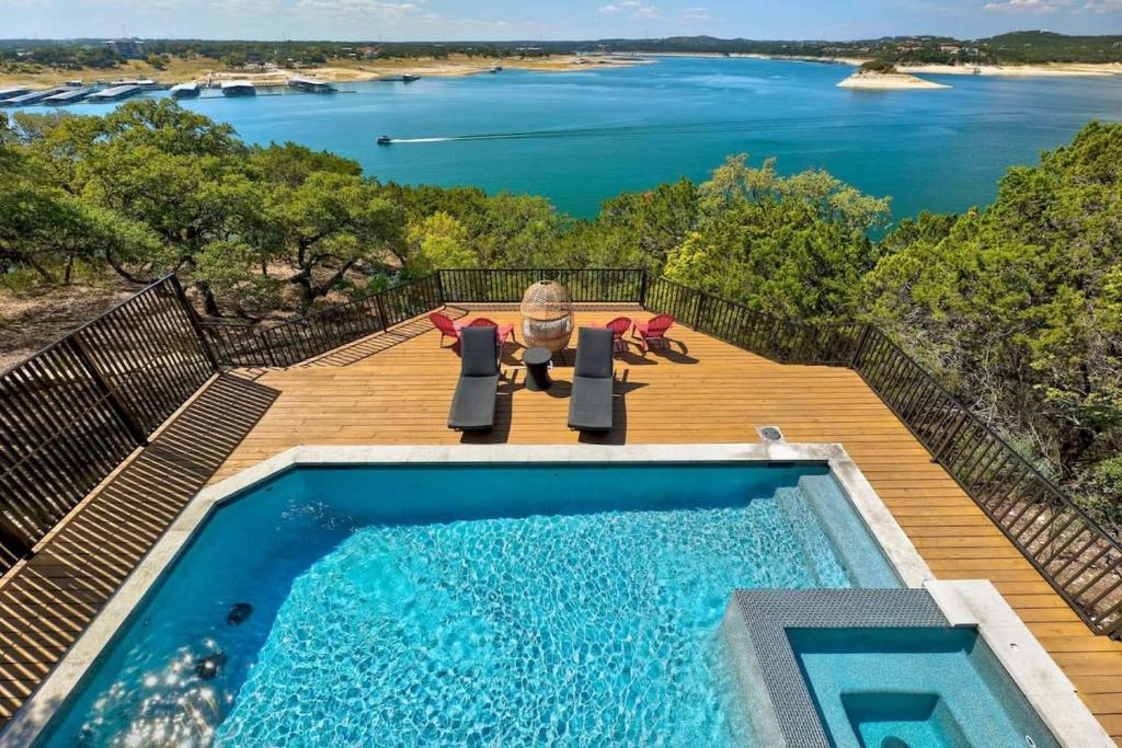 a pool on a deck with a view of the water at Atlantis - Front Row View of Lake Travis in Leander