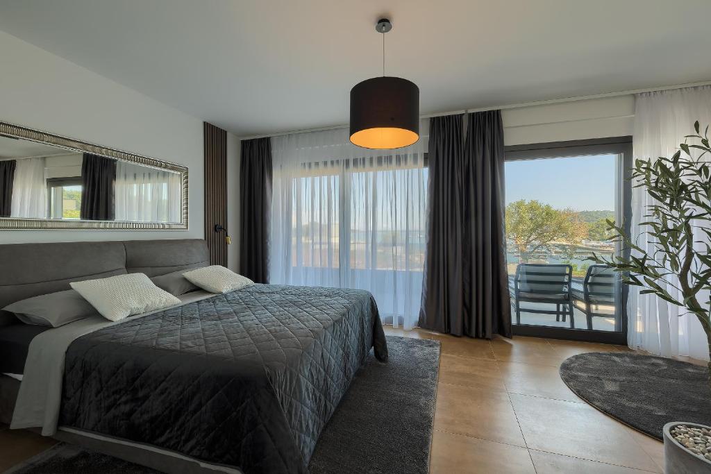 a bedroom with a bed and a large window at Villa Skalica Pomer - Medulin SEA VIEW in Pomer