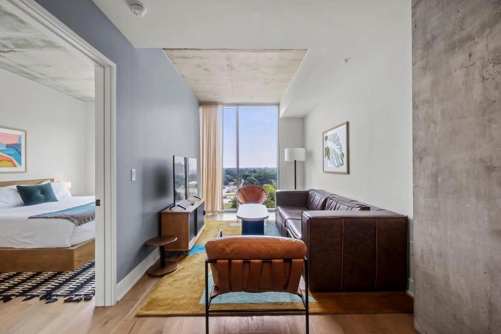 Un dormitorio con una cama y una sala de estar con un sofá. en Modern 1BR Condo on Rainey St with Pool and Views, en Austin