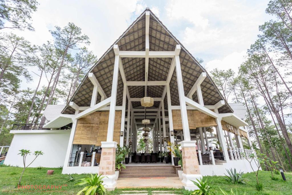 ein Gebäude mit einem dreieckigen Dach in einem Park in der Unterkunft vKirirom Pine Resort in Chambok