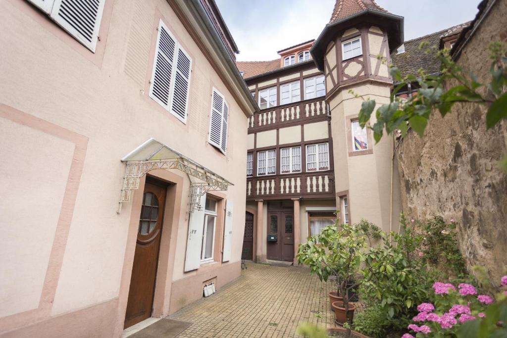 a courtyard of a building with a clock tower at Romantic Studio Center in Colmar