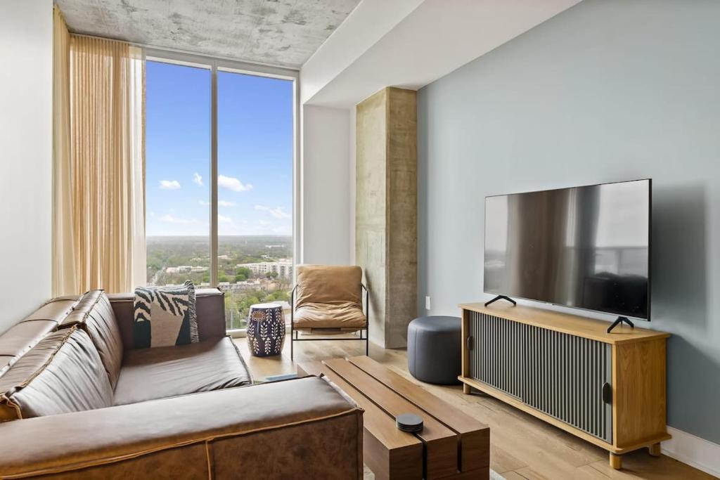 a living room with a couch and a flat screen tv at Luxe Condo in Downtown Austin in Austin