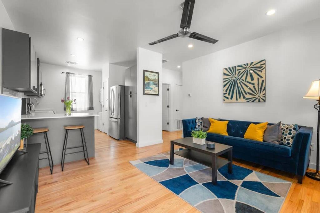 a living room with a blue couch and a kitchen at Modern Condo with Parking - B in Austin