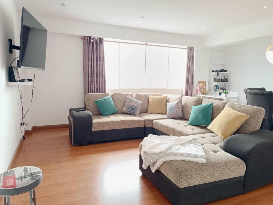 a living room with a couch and a tv at Apartamento moderno y céntrico en Lima, 3 Dormitorios in Lima