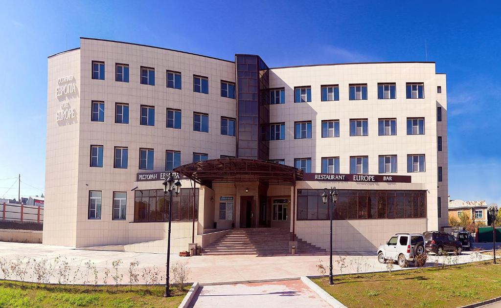 a building with a white van parked in front of it at Business Hotel Europa in Khabarovsk