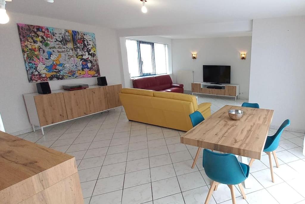 un salon avec un canapé, une table et des chaises dans l'établissement Appartement tout-terrain !, à Metz