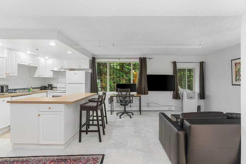 a kitchen and living room with white cabinets and a table at Starlit Cozy Studio in Elektra with Roof Decks in Seattle