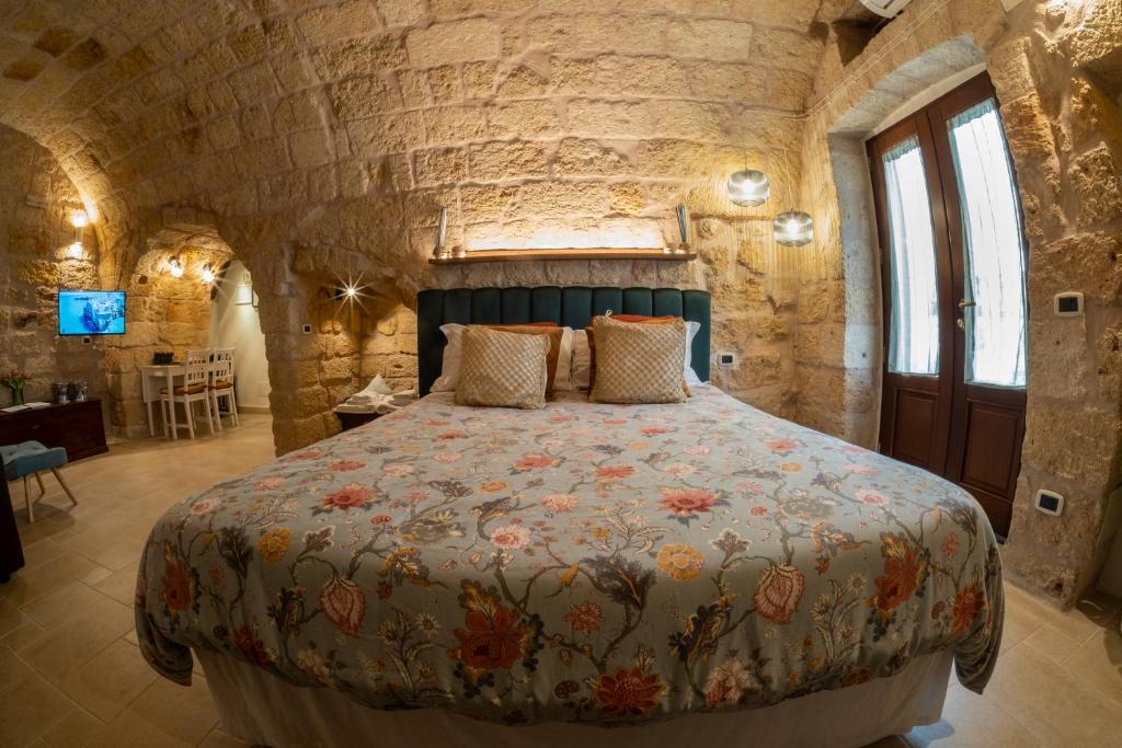 een slaapkamer met een groot bed in een stenen muur bij Dimora 181 in Polignano a Mare