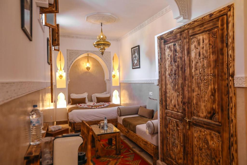 sypialnia z łóżkiem i dużymi drewnianymi drzwiami w obiekcie Riad Anya & SPA w Marakeszu
