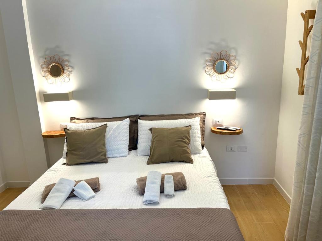 1 dormitorio con 1 cama con 2 almohadas y 2 espejos en Monolocale Home nel cuore di Otranto abbonamento parcheggio gratis, en Otranto