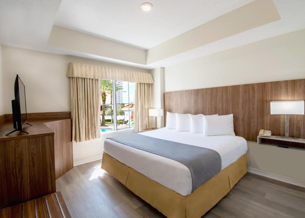A bed or beds in a room at The Point Hotel & Suites Universal