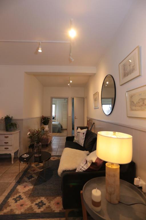 een woonkamer met een bank en een tafel bij Spacious 1-Bedroom Family Apartment in Partille Center near Gothenburg with Kitchen, Garden Access and Free Parking in Göteborg