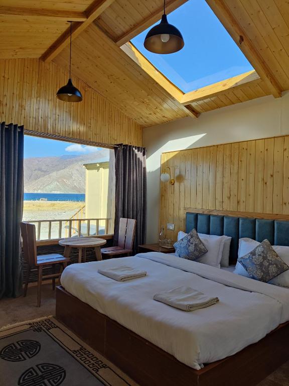 ein Schlafzimmer mit einem großen Bett und einem großen Fenster in der Unterkunft Rangjon Resort in Meruk