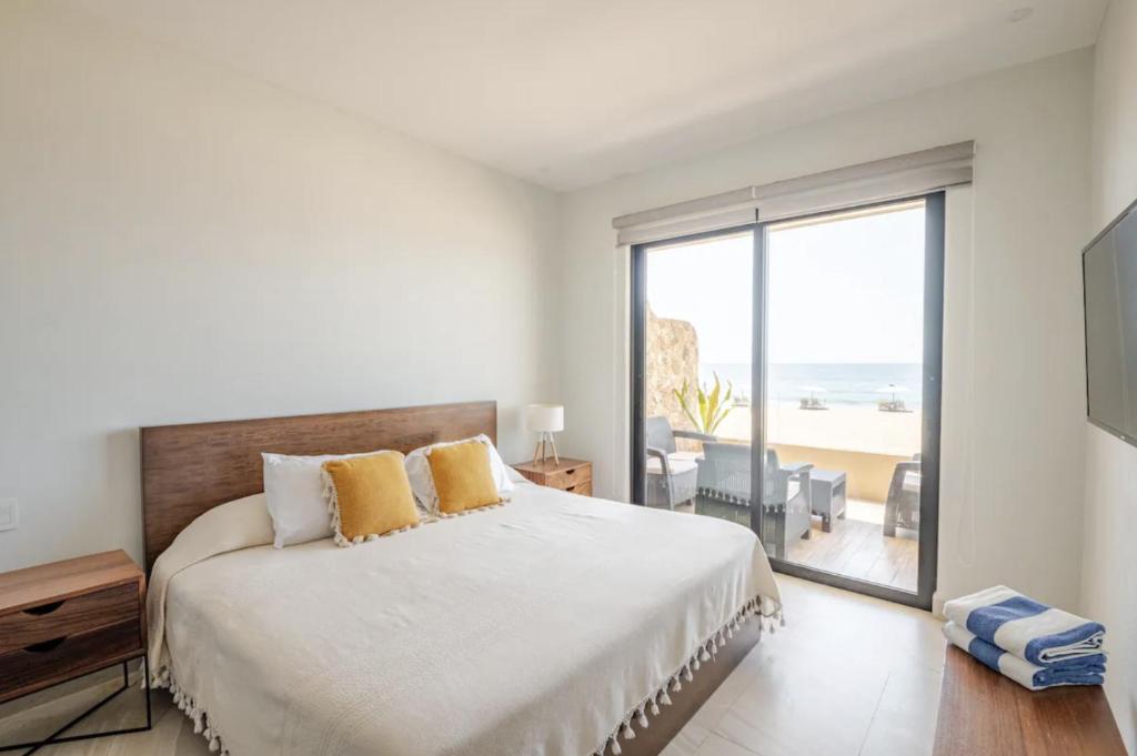 a bedroom with a large bed with a view of the ocean at Oceanfront condo with terrace in San Francisco