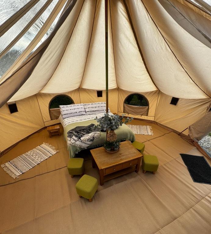 a tent with a bed and a table in it at Polladras Holiday Park in Helston