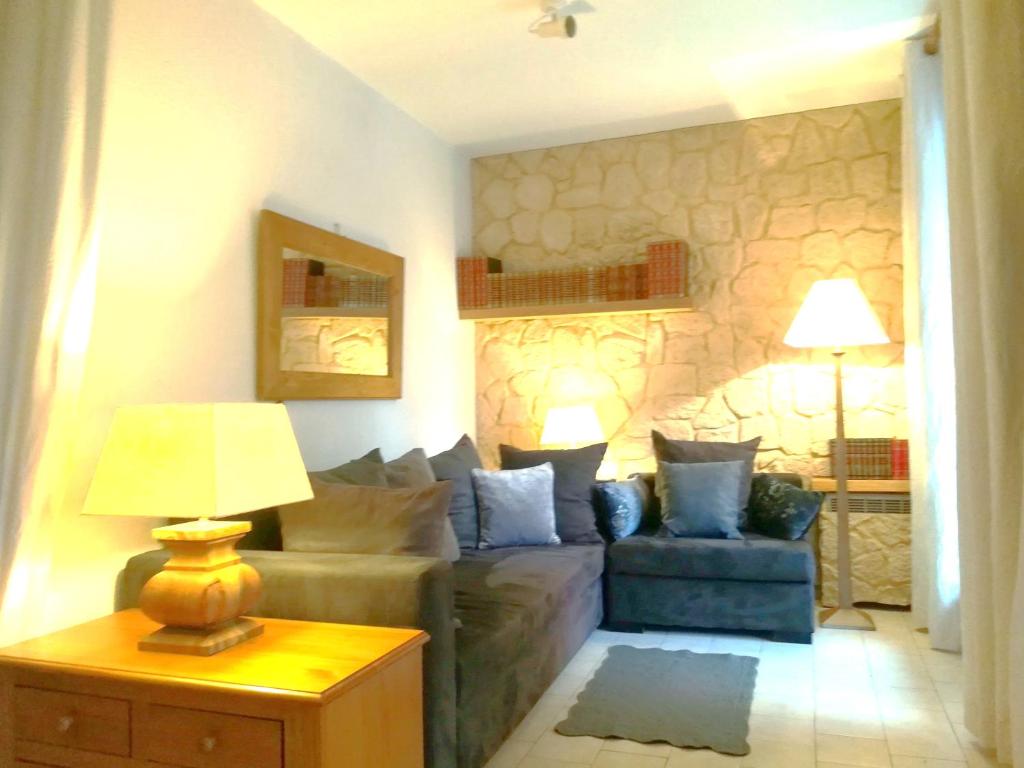 a living room with a couch and a table with a lamp at Villa Thermaë Face aux thermes avec jardin privatif in Gréoux-les-Bains