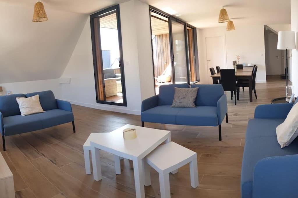 un salon avec des canapés bleus et une table dans l'établissement Les Hauts de la Belle Époque, à Carnac