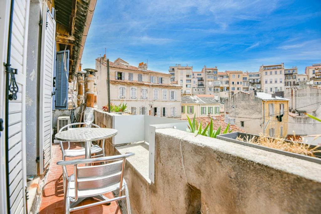 - un petit balcon avec une table et des chaises dans un bâtiment dans l'établissement Appart cosy à 5 min de la plage des Catalans, à Marseille