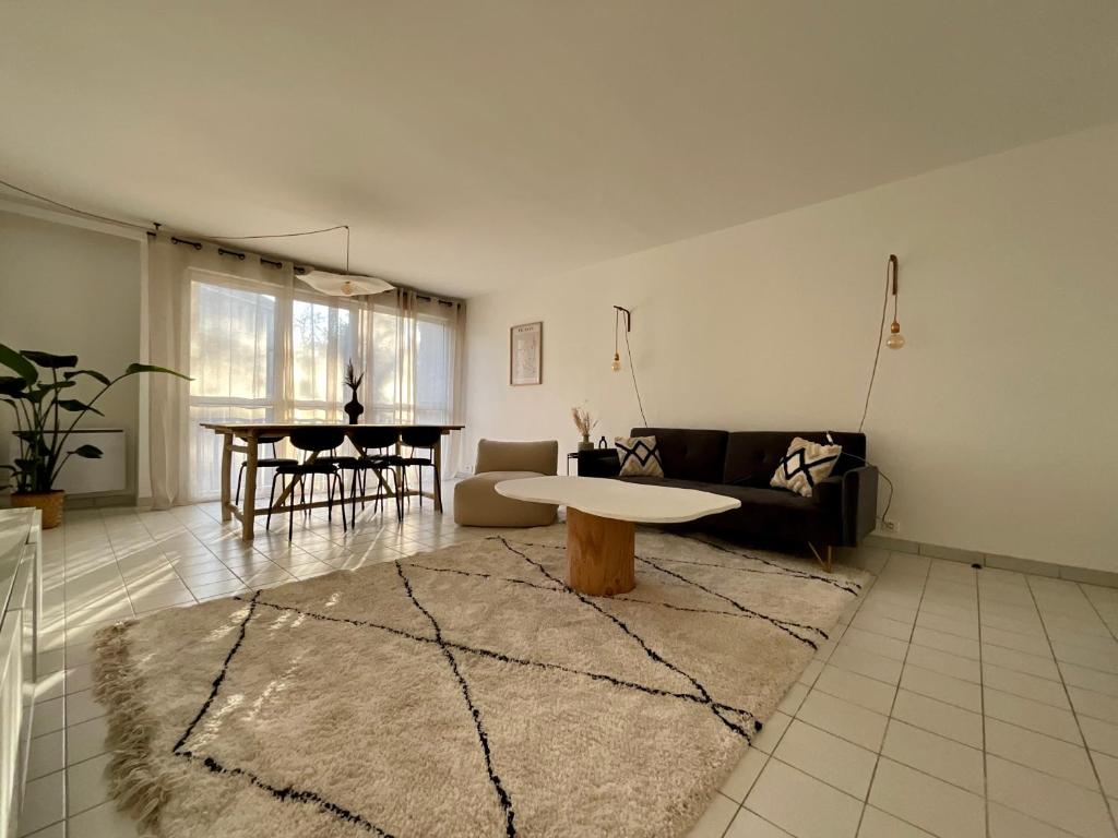 un salon avec un canapé et une table dans l'établissement Appartement 3 chambres, à Clamart