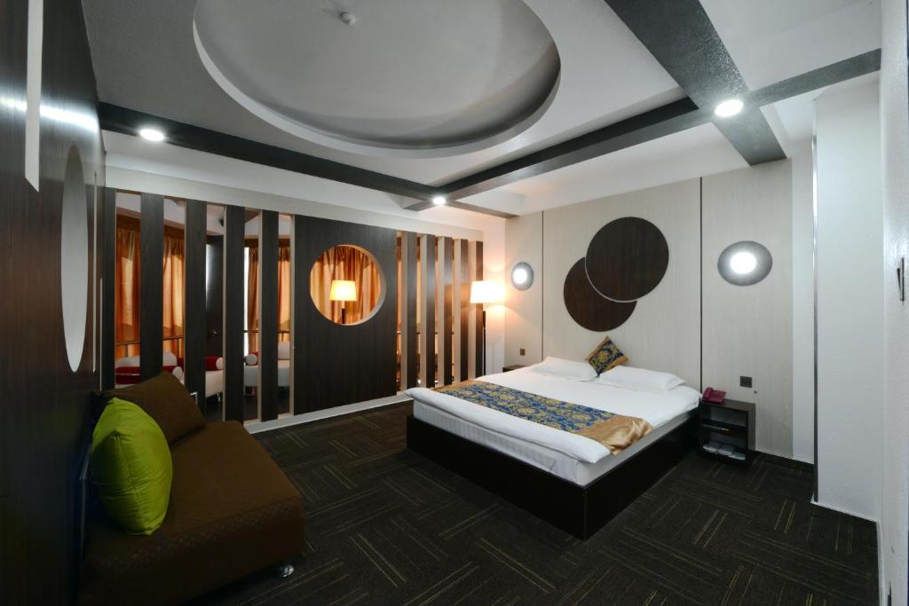 um quarto com uma cama e um sofá em Zolo Hotel em Ulan Bator