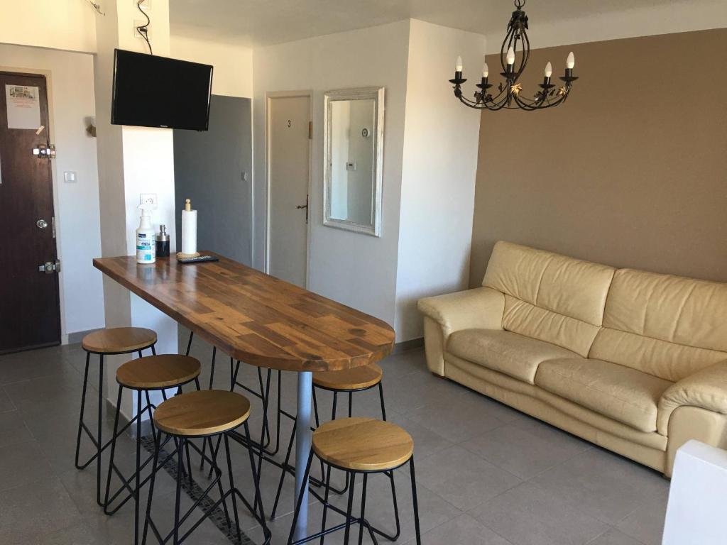 - un salon avec une table, des tabourets et un canapé dans l'établissement Grands Buffets hébergement Appartement Narbonne, à Narbonne