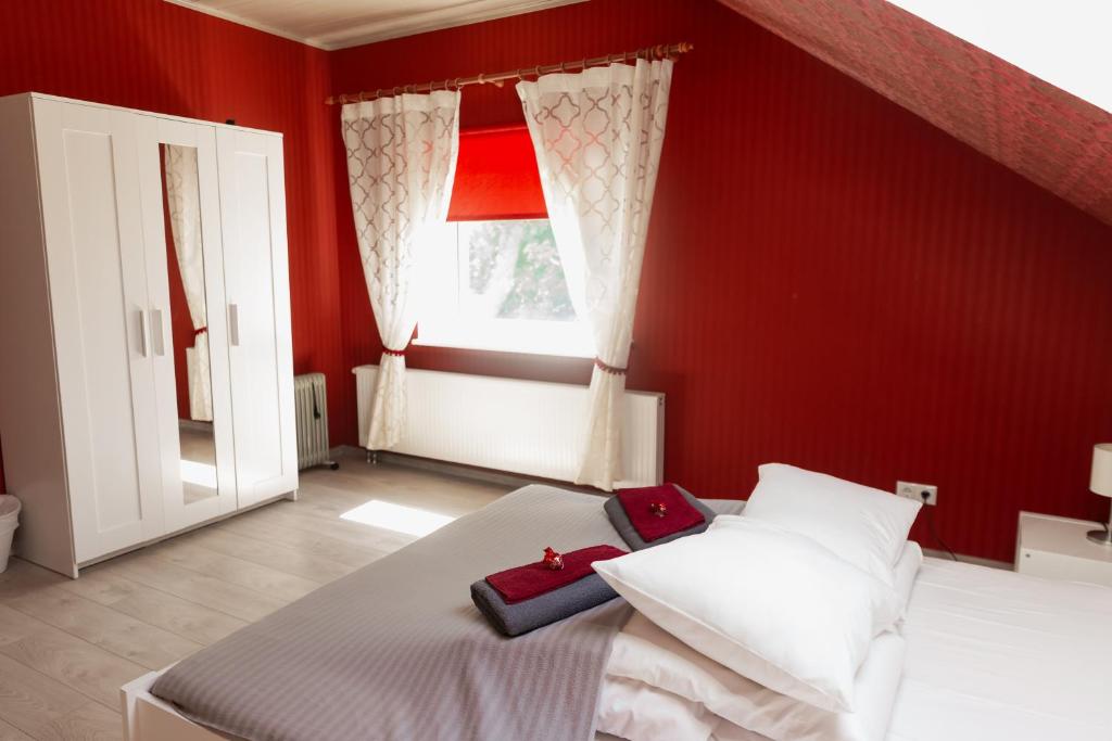 Dormitorio rojo con cama y ventana en Konrad Family Guesthouse, en Kuressaare