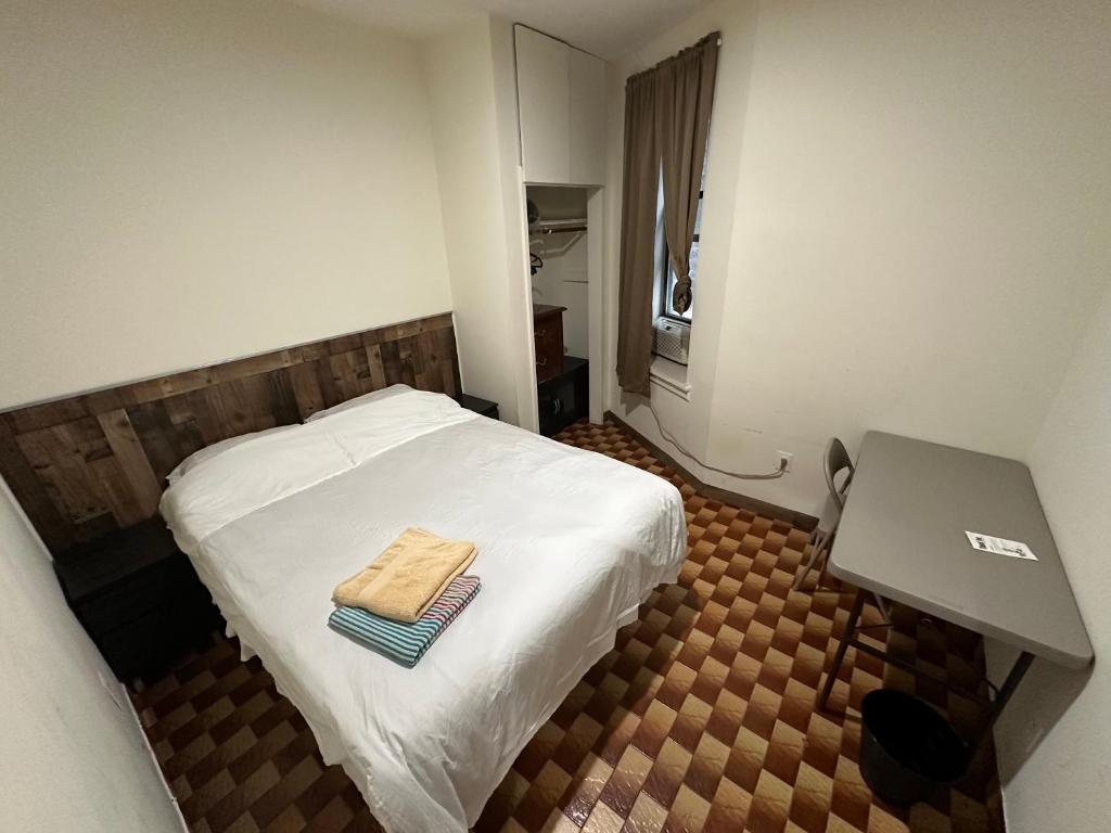 a small room with a bed with a towel on it at Hudson Yard 408 in New York