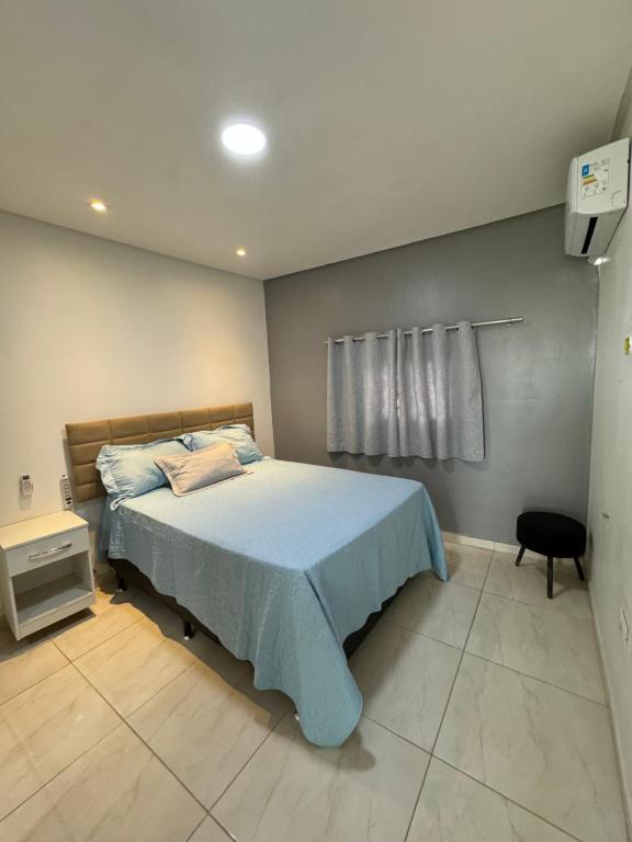 une chambre avec un lit recouvert d'une couette bleue dans l'établissement Flat Cactos, à Surubim