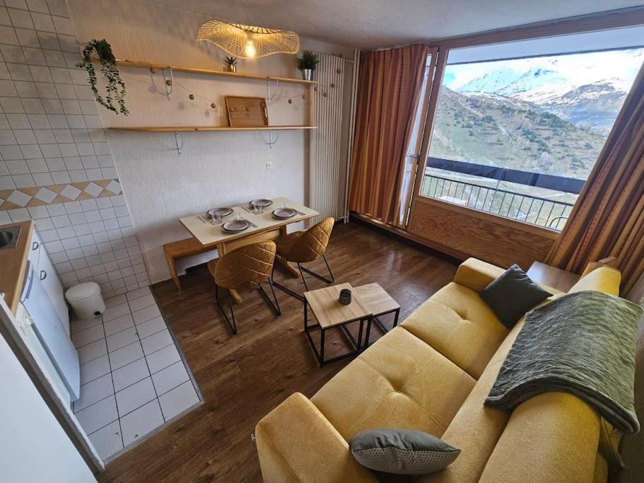 un salon avec un canapé et une cuisine avec une table dans l'établissement Appartement - Superbe vue, à Tignes