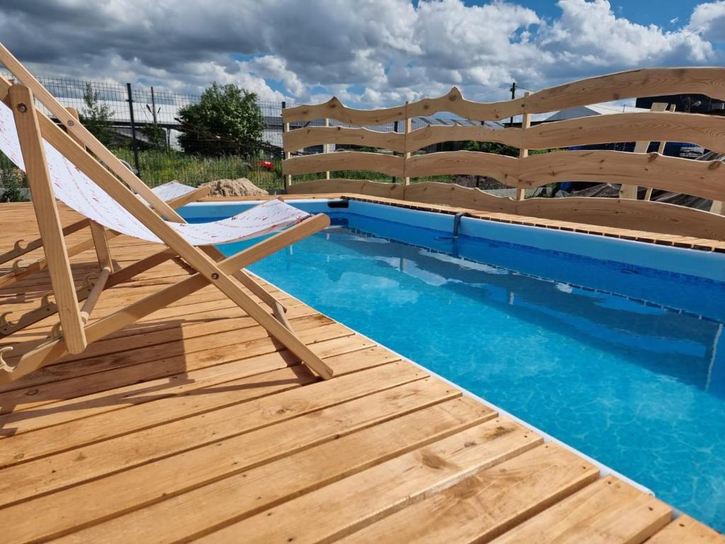 a deck with a chair and a swimming pool at Apartamenty Welskie in Lidzbark