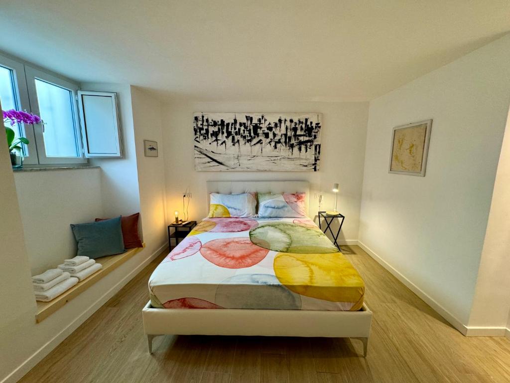 a bedroom with a large bed with colorful sheets at Residenza d'Artista al Duomo1 in Salerno