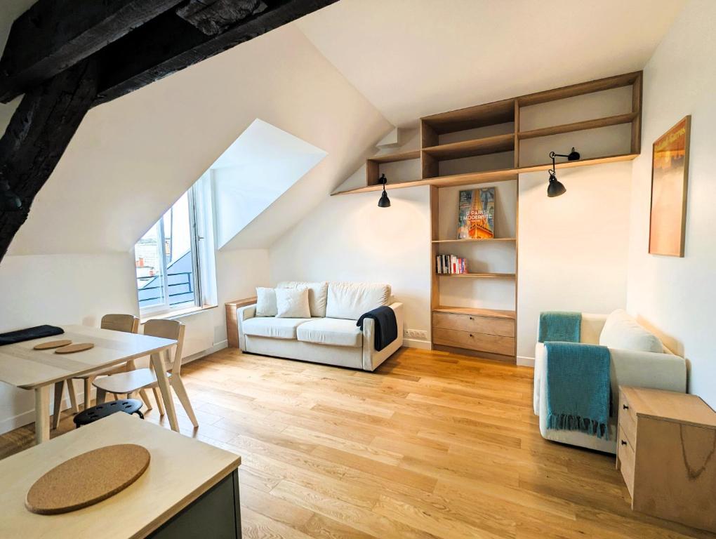 un salon avec un canapé et une table dans l'établissement Appart sur les toits de Paris - Marais, à Paris