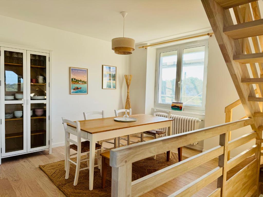 une salle à manger avec une table et des chaises en bois dans l'établissement Bord de mer en Bretagne Sud, à Névez