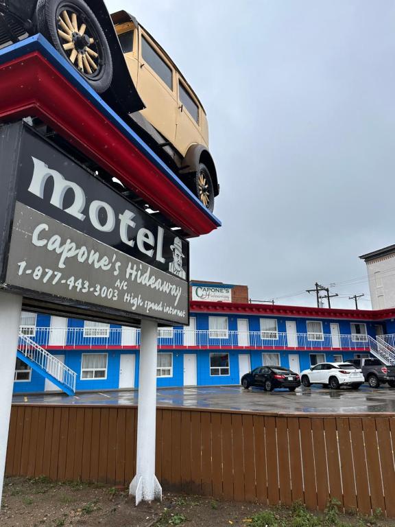 a sign with a truck on top of a building at Capone's Hideaway Motel in Moose Jaw