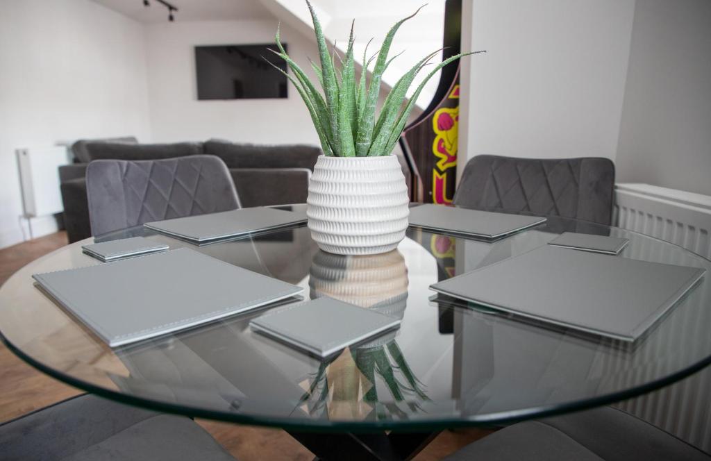 a glass table with a vase with a plant on it at Gynn Stays - Apartment Two in Blackpool