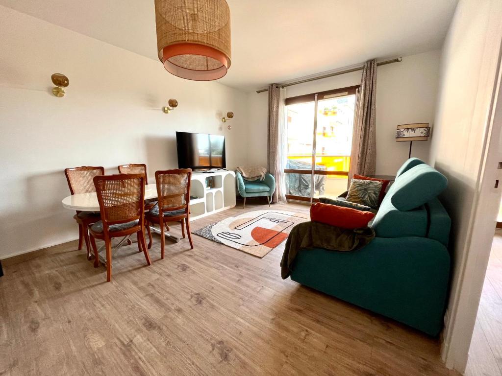 un salon avec un canapé vert et une table dans l'établissement Le Nid de Plage à 100 m de la mer, à Cabourg
