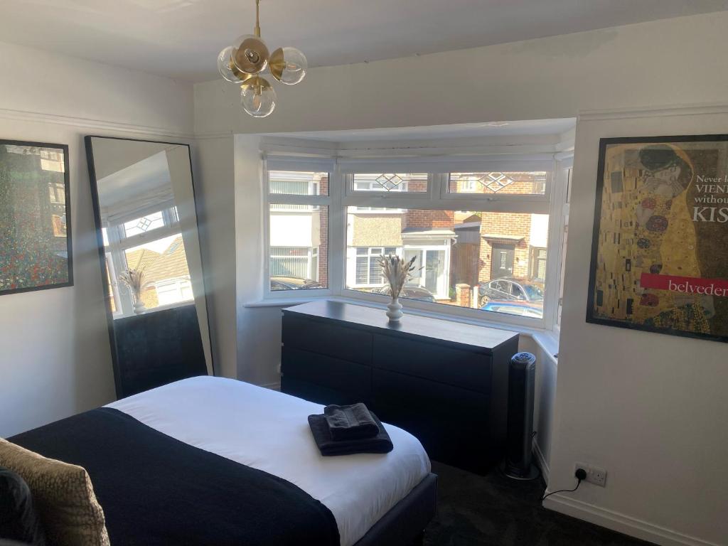 リバプールにあるLovely 2 Bed Full House By The Beachのベッドと窓のある寝室