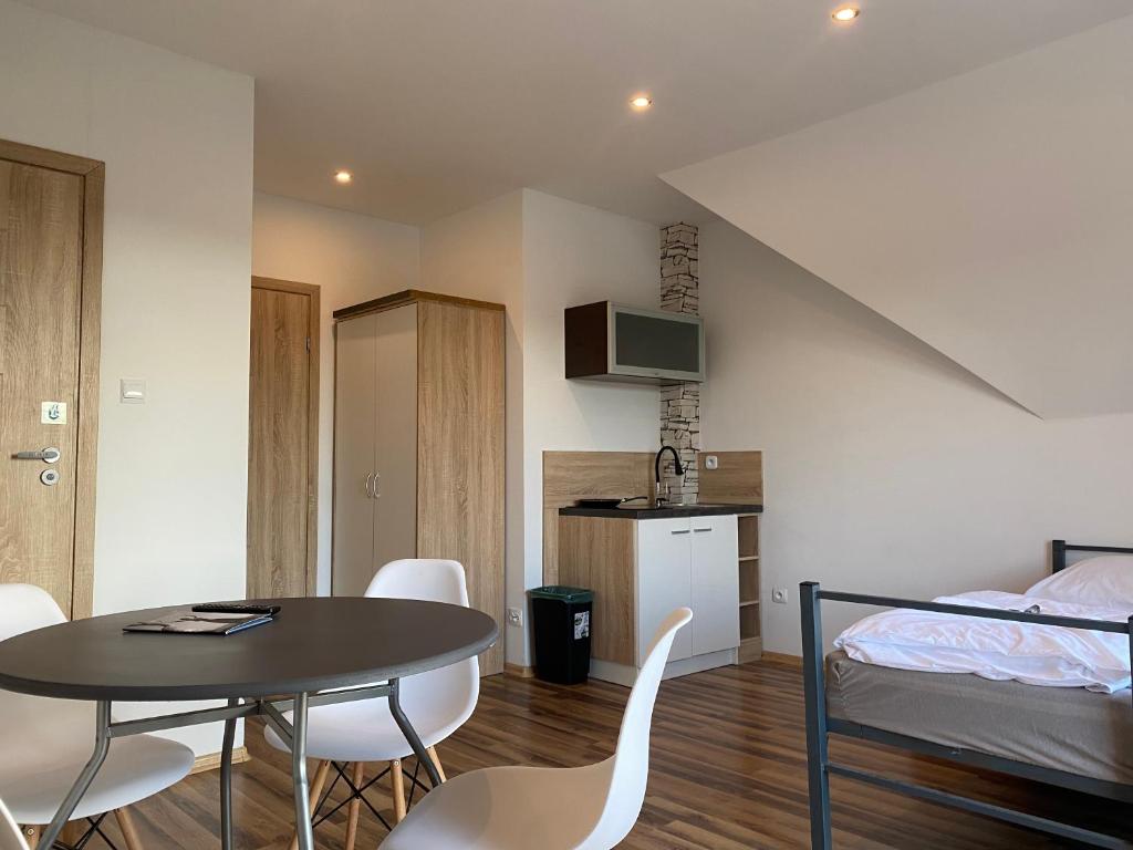 a room with a table and a bed and a kitchen at House Hostelli in Grzybowo